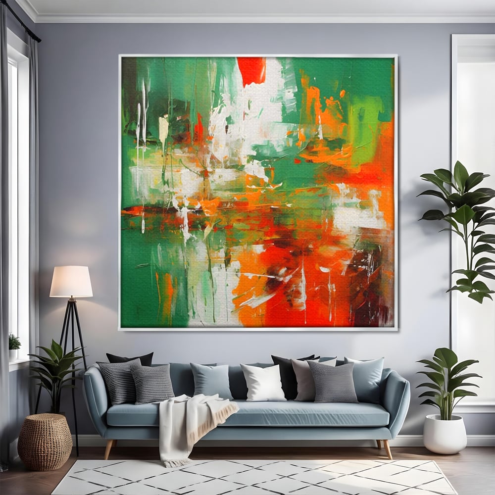 Tablou canvas cu pictura abstracta cu verde si portocaliu, in rama de aluminiu argintiu, pe perete intr-un living